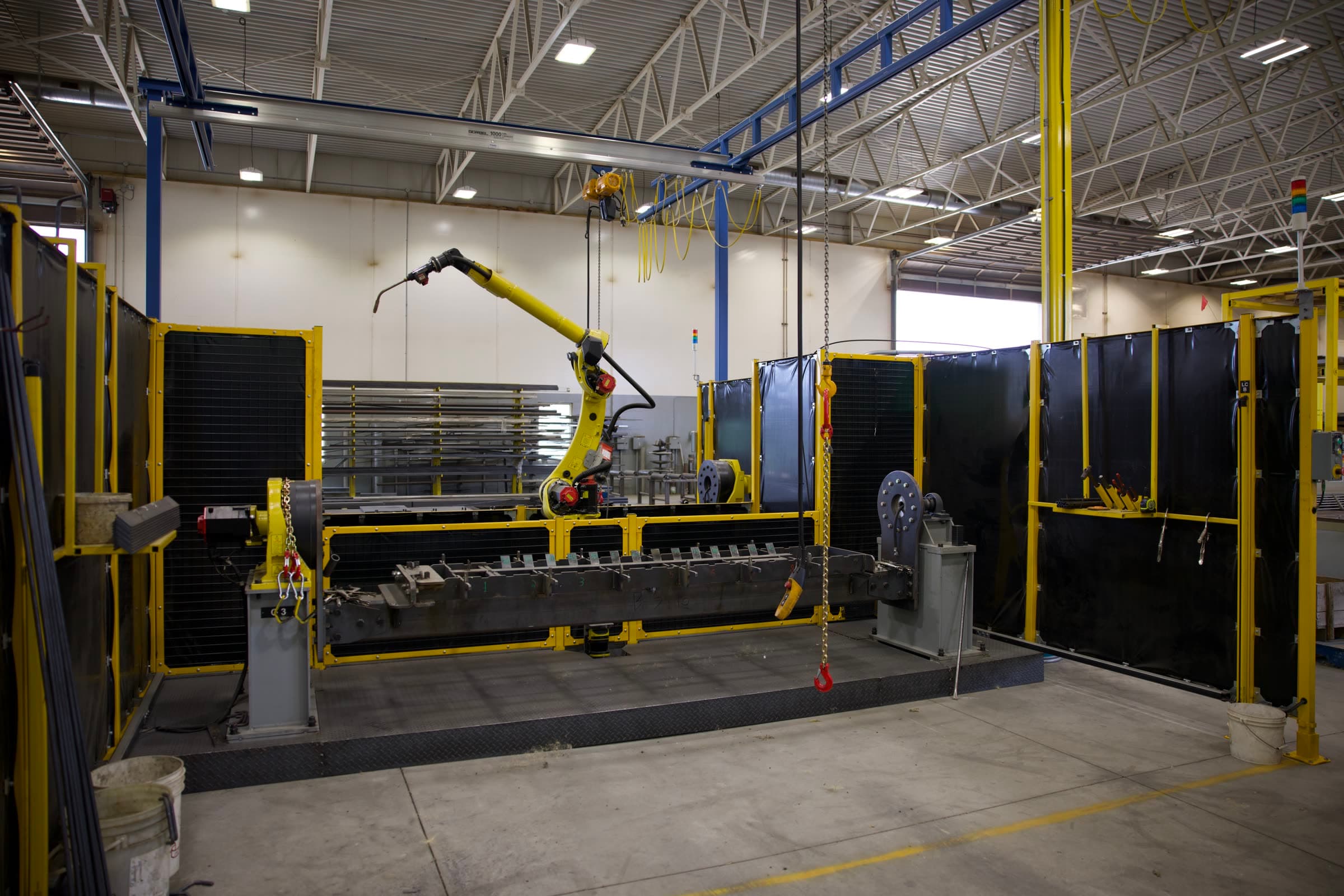 Robotic welding cell with positioners and a long steel frame fixtured between headstocks
